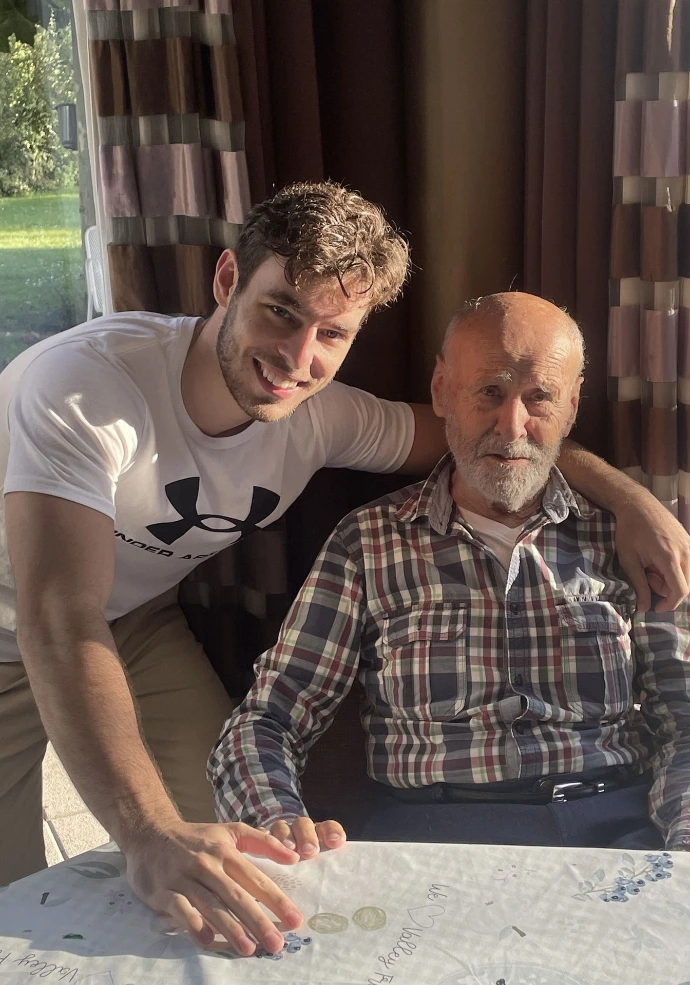 Persoonlijke assistentie waarbij een jonge man zijn arm om een oudere man legt